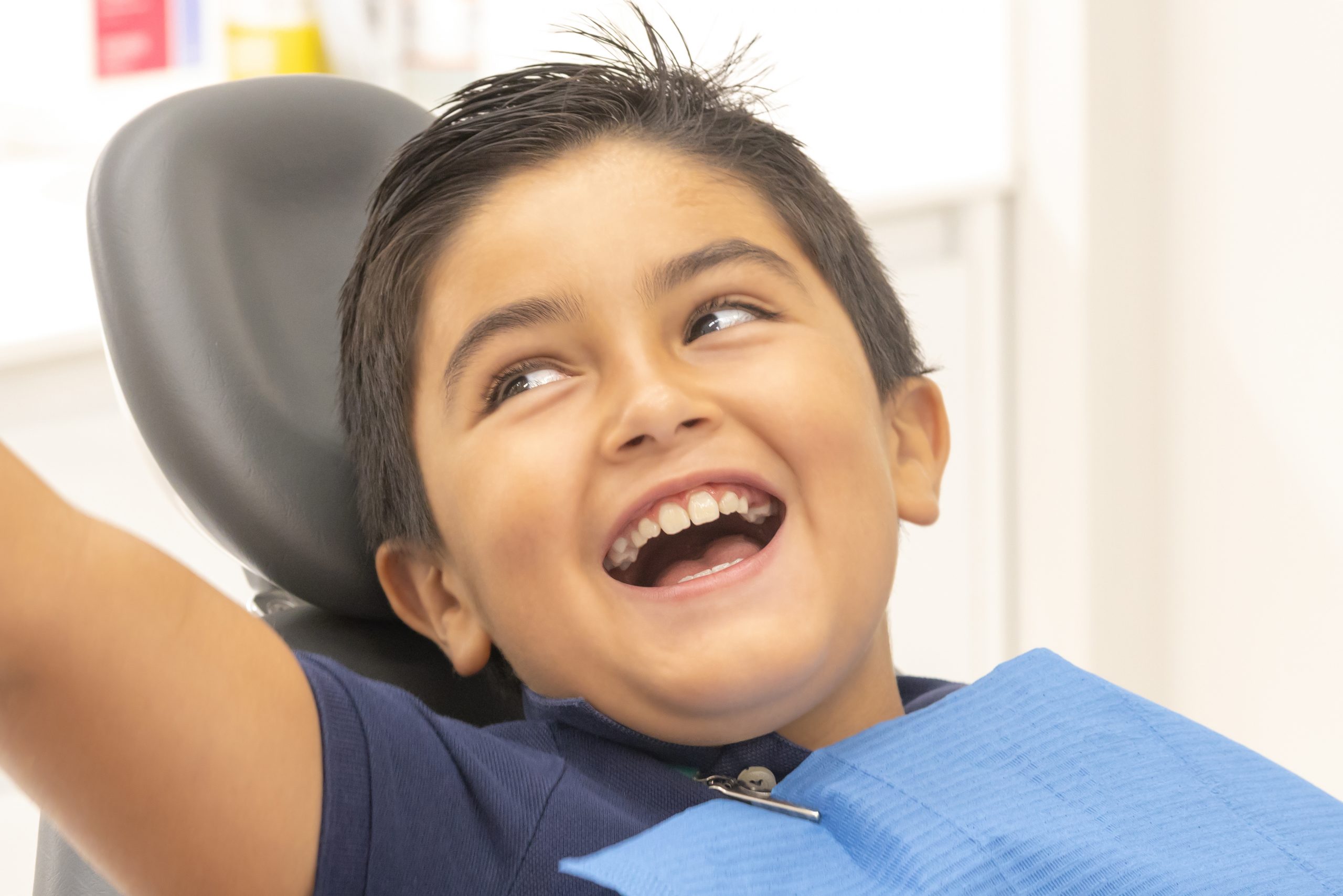 Niño en la camilla del dentista sonriendo