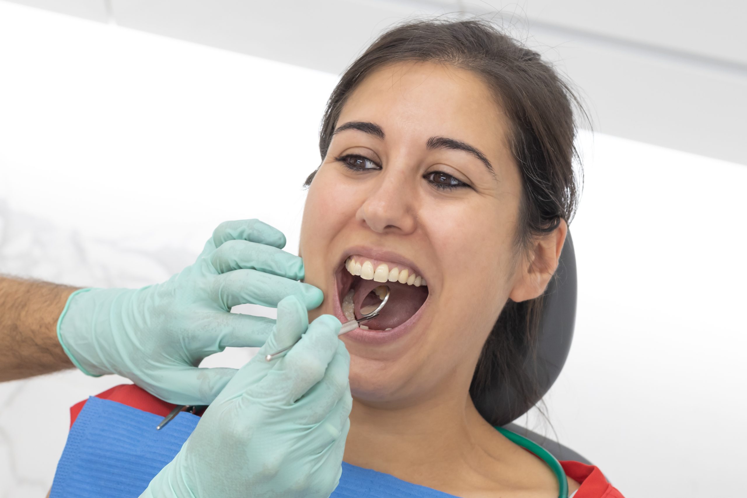 Dentista actuando en la boca de paciente