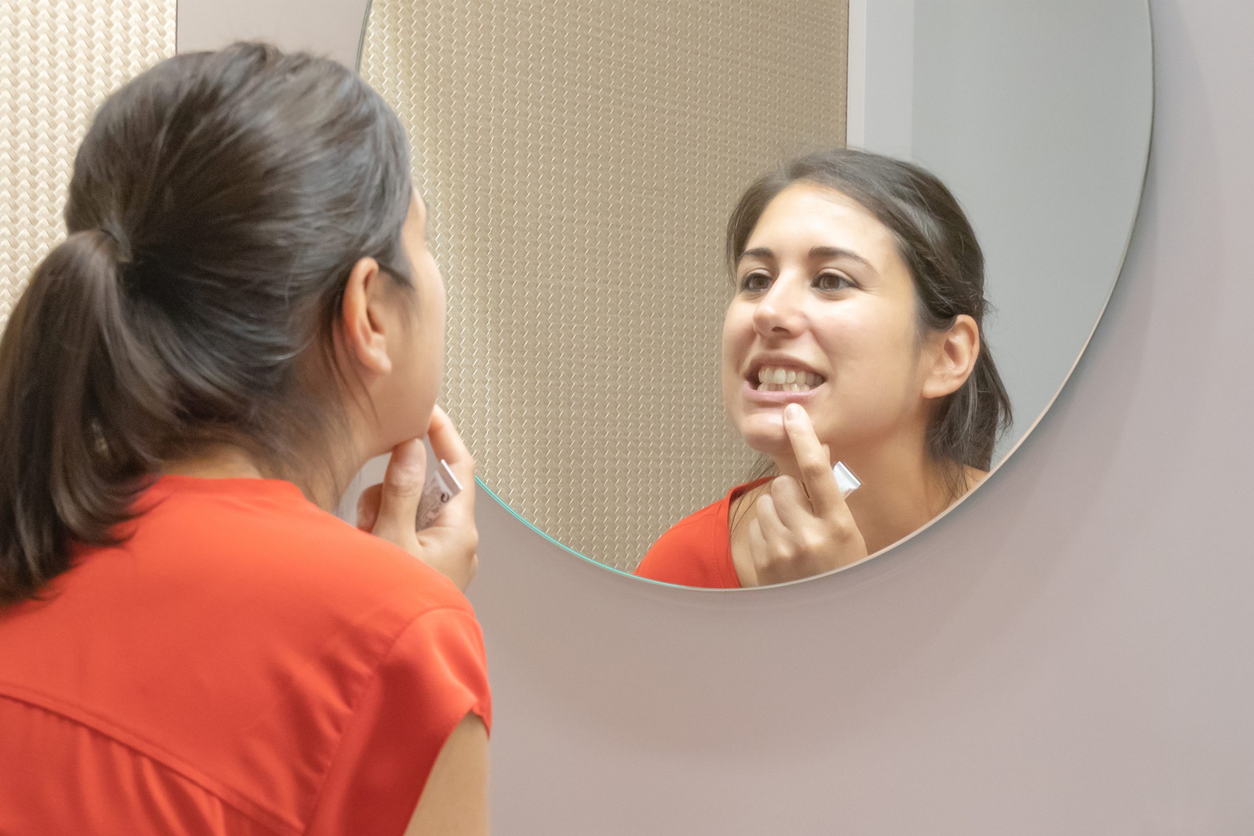 Mujer mirando su boca frente al espejo
